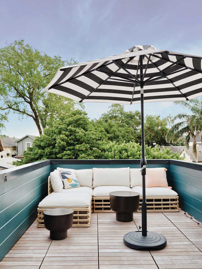 Terrace with striped umbrella and patio furniture in contemporary home