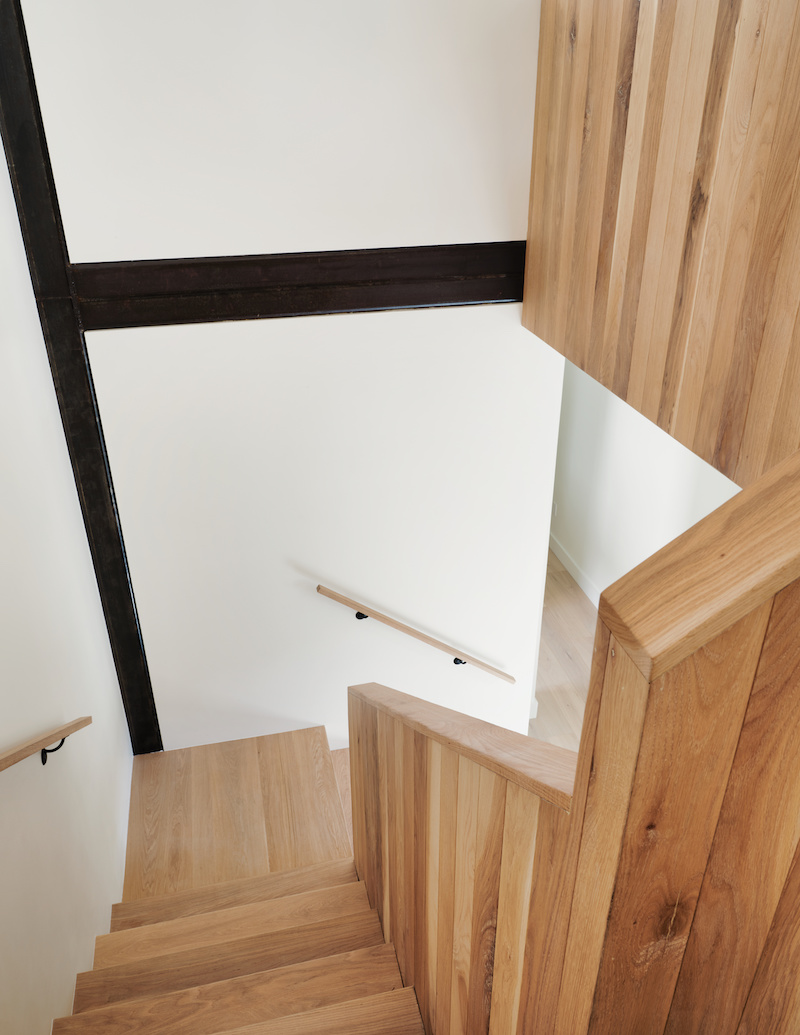 Staircase in a railroad style home with white oak and steel beam structural support in contemporary home 
