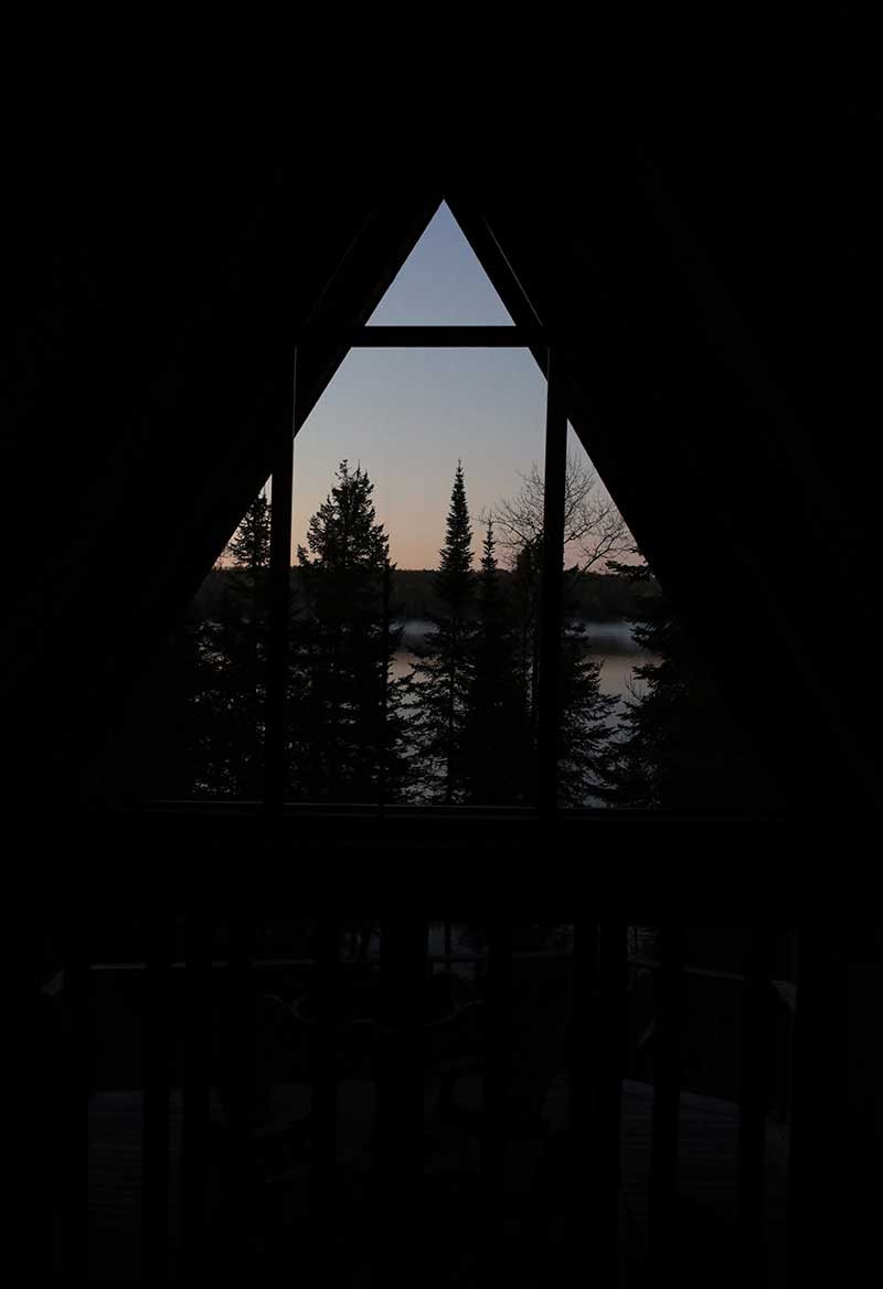 Night time at The Minne Stuga, featuring Marvin Ultimate windows and doors and a view of trees outside.