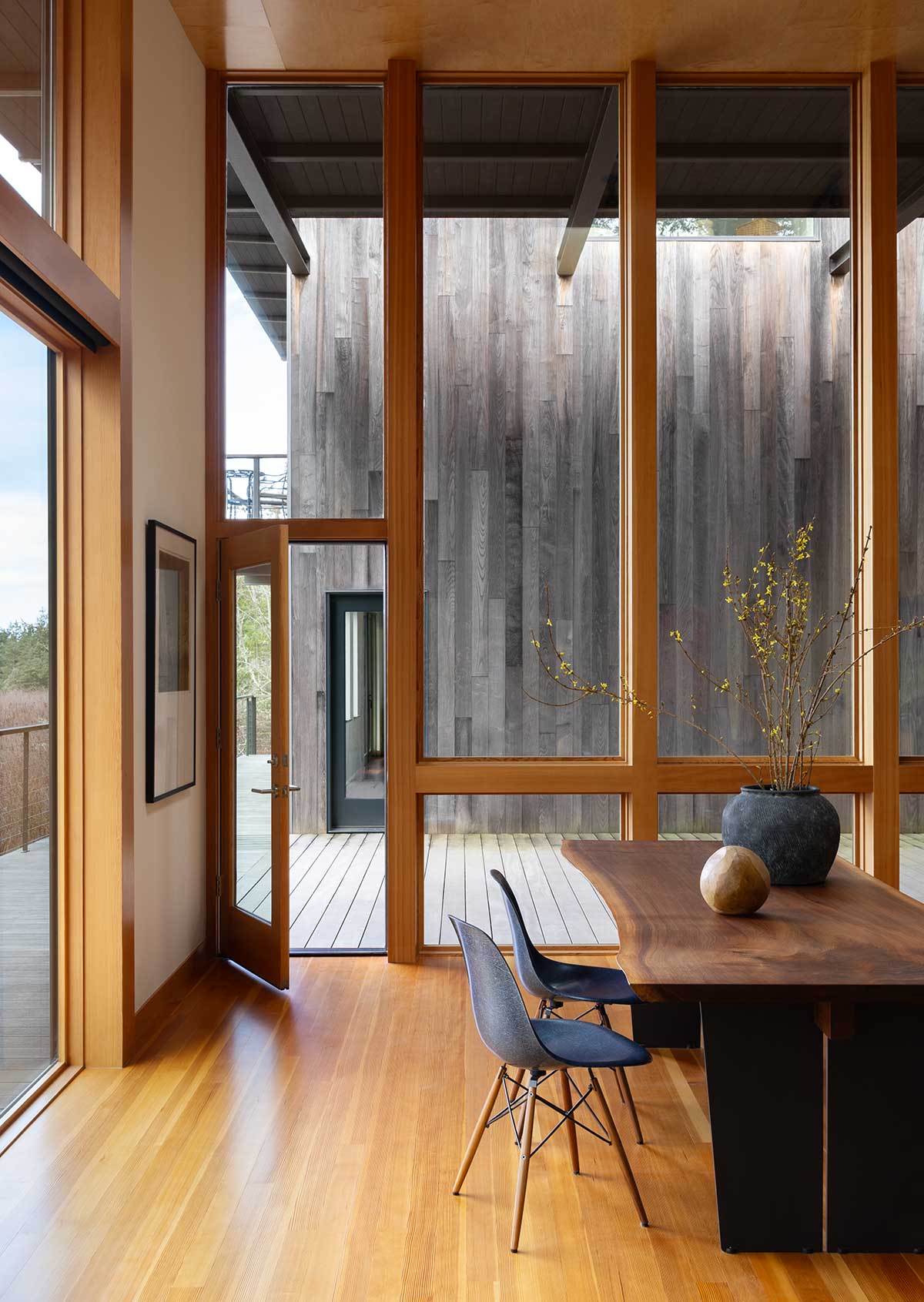 A modern living space, featuring a long live edge table, a Marvin Ultimate Multi-Slide door and Marvin Ultimate direct glaze windows.