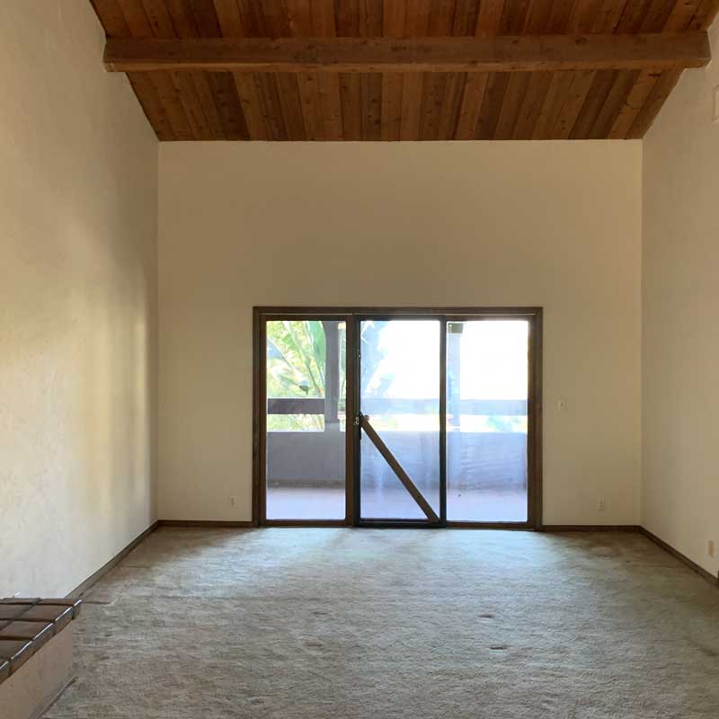 A before image of the living room in the Bobby Berk Firm’s office space, which was previously a dated 70s Spanish Mediterranean home.