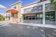 Exterior of retail building with Marvin Signature Coastline Bi-fold Door and Storefront Picture Window