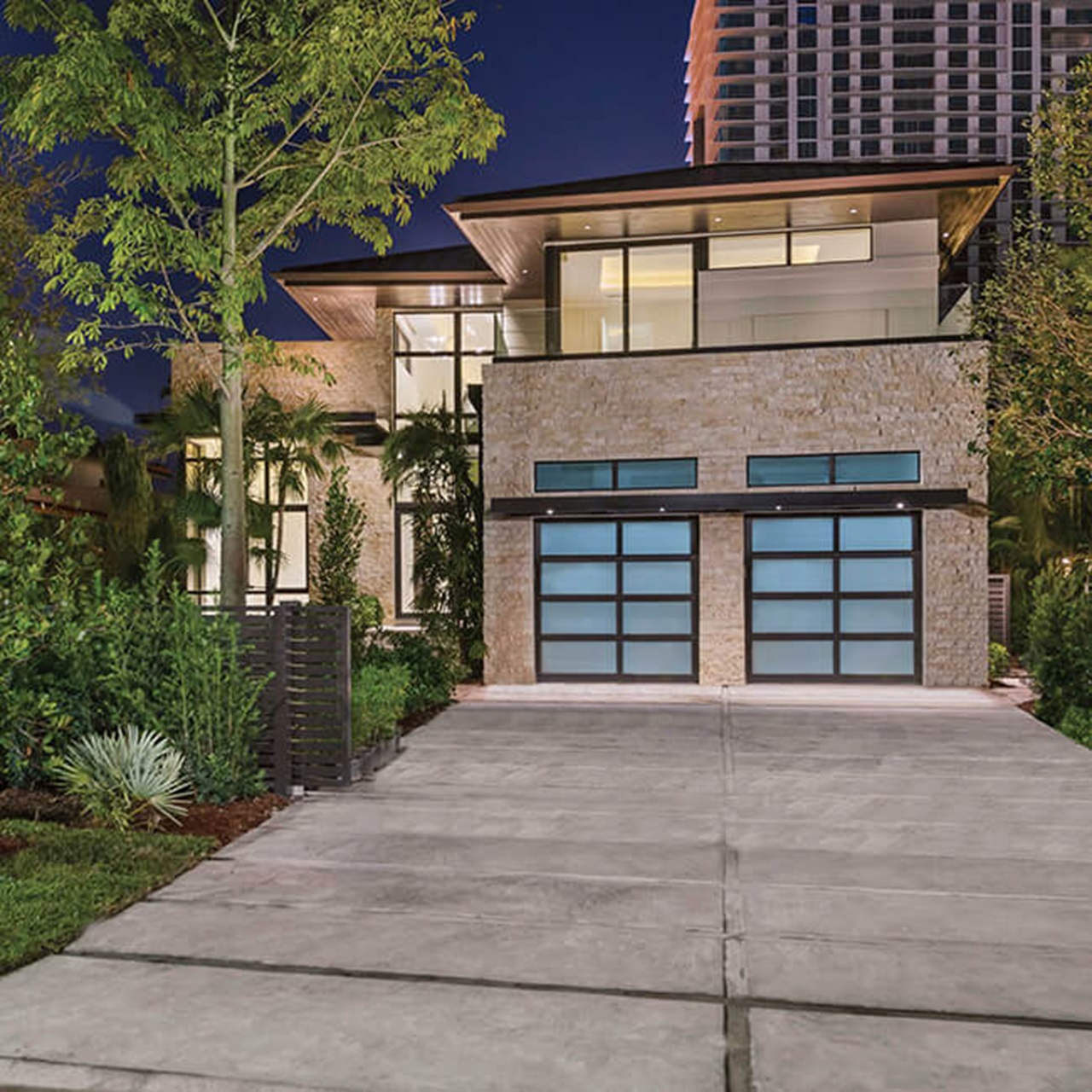 Exterior of modern style home with Marvin Signature Coastline Direct Glaze Narrow Frame Window Multi-Slide Door and Glass Garage Doors