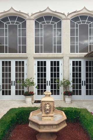 Exterior of home with Marvin Signature Coastline Outswing French Doors and Round Top Narrow Frame Windows