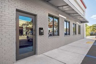Exterior of retail building with Marvin Signature Outswing French Door and Storefront Picture Window