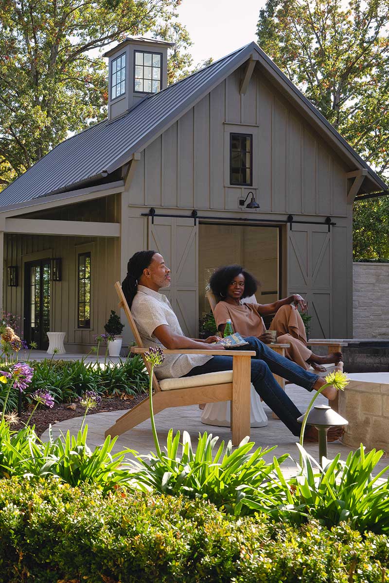 Man and woman sitting in front of home with Marvin Elevate Casement windows and inswing french door