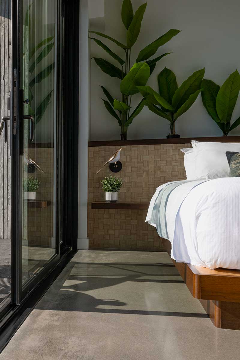 A private guest suite with Marvin Elevate Sliding door and bed surrounded by plants at the Viewpoint Hotel in York, Maine.
