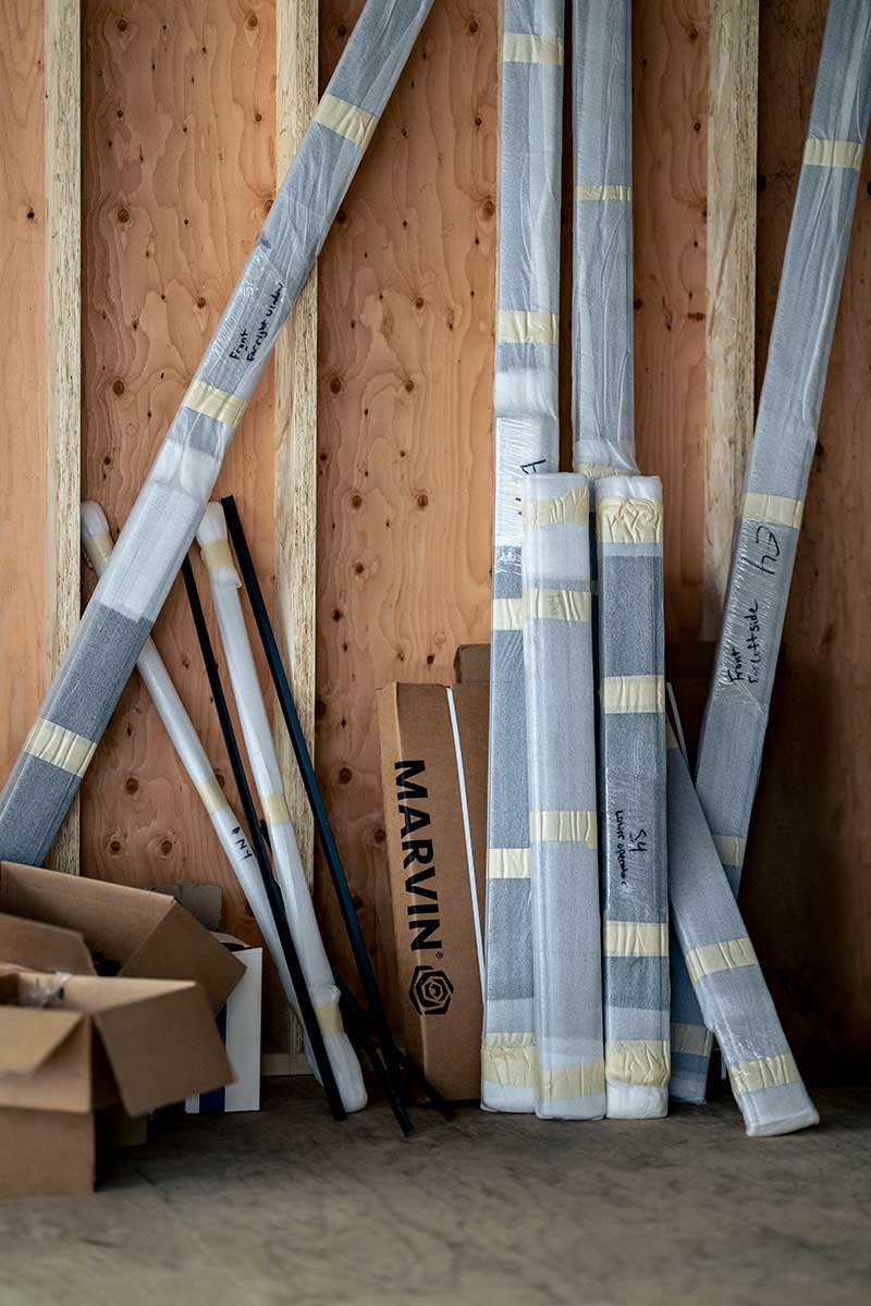 A pile of materials leaning up against a wall in an under construction home.