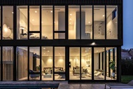 Exterior of a modern home at night with lights on