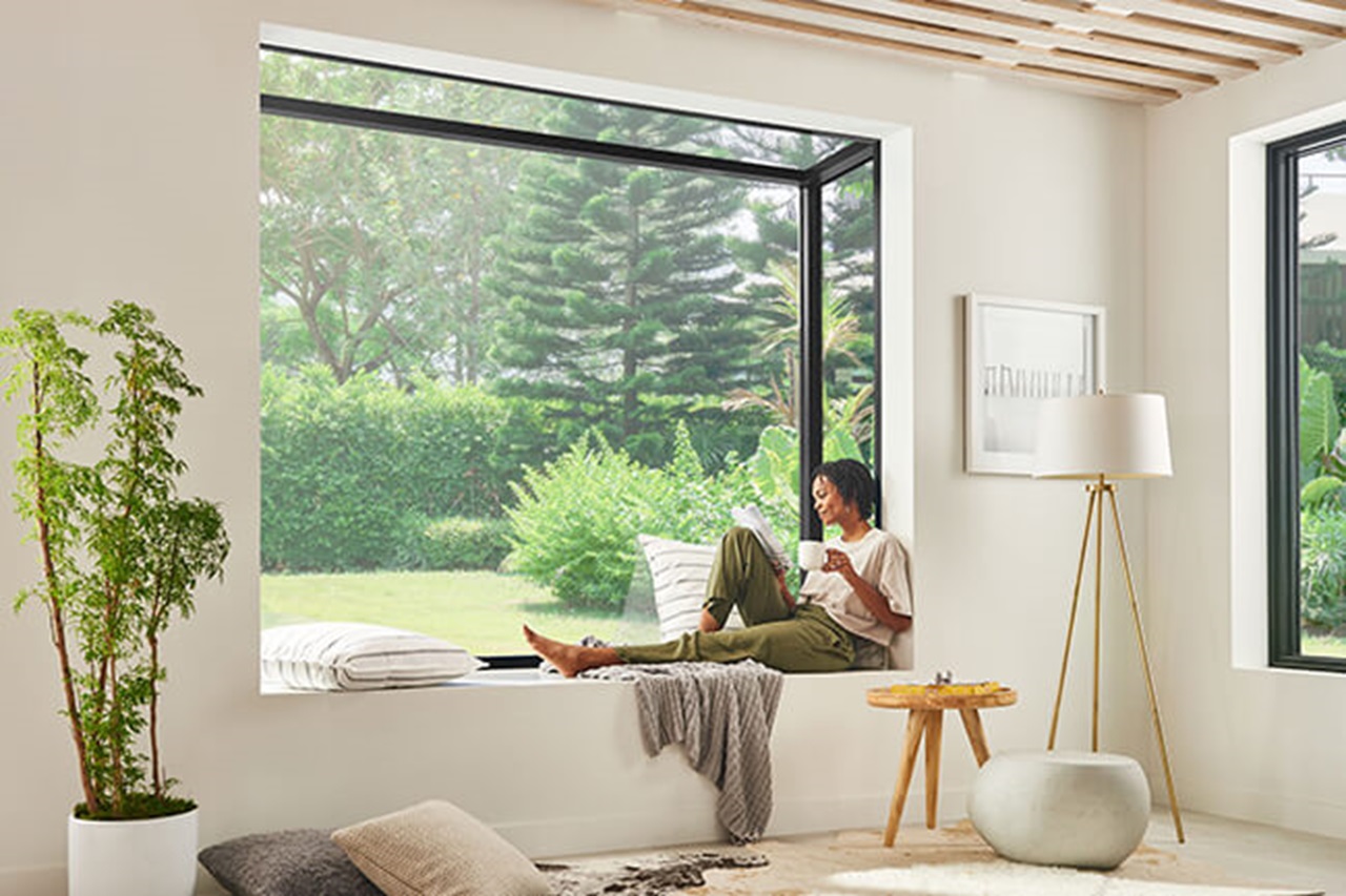 woman sitting in Marvin's Skycove projected glass box window