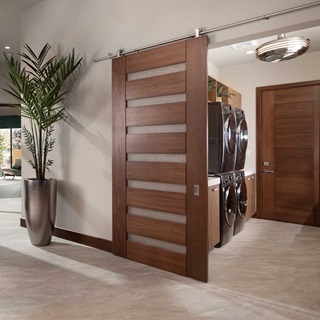 An extra wide TruStile barn door with  horizontal planks, open to reveal a laundry room with two pairs of stacked washer and dryer.