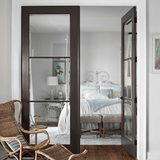 An open TruStile French door leading into a country style bedroom.