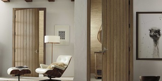 A sitting room next to a bathroom with TruStile doors and wood beams on the ceiling.