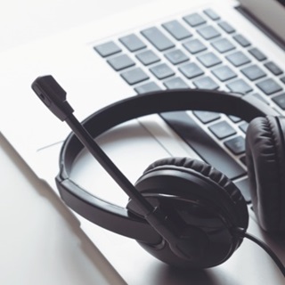 Headset laying on top of laptop computer