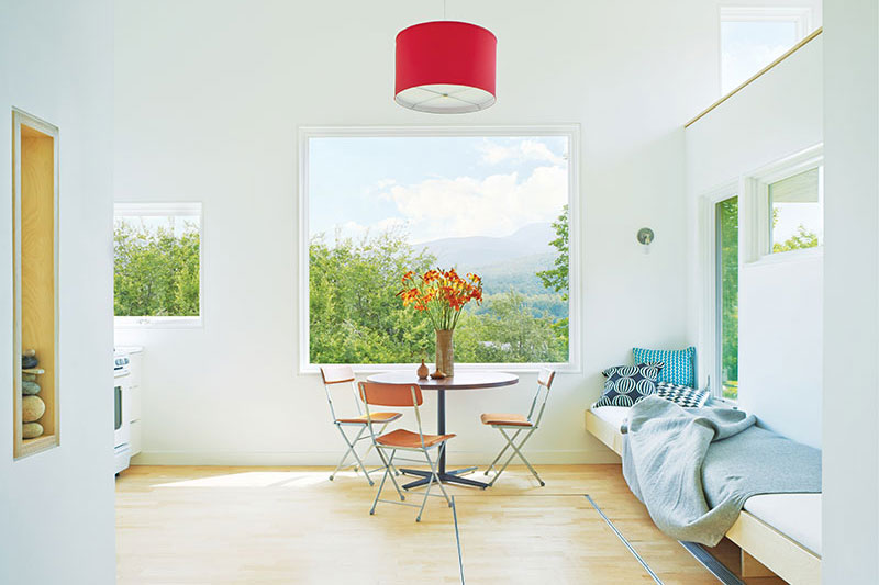 The eating and living area of a micro house in Vermont, featuring Marvin windows and doors.