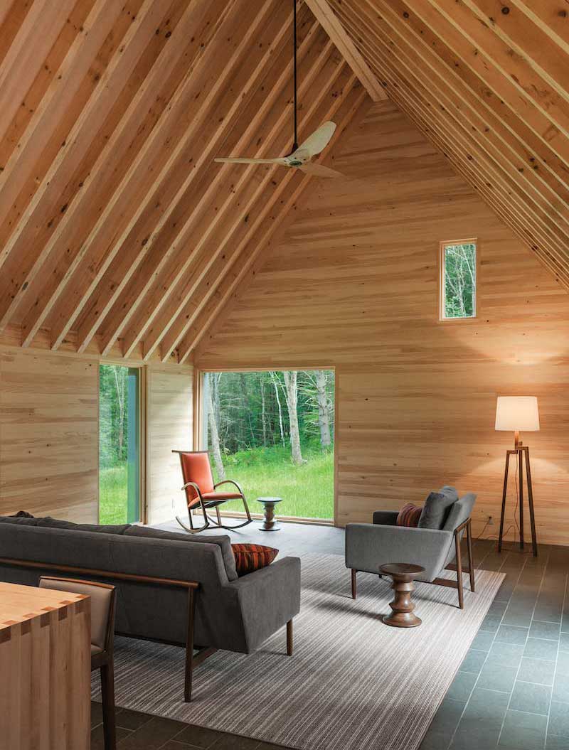An interior photo of the living space inside the Marlboro Music Cottages, featuring Marvin Ultimate Casement windows and Ultimate Picture windows.