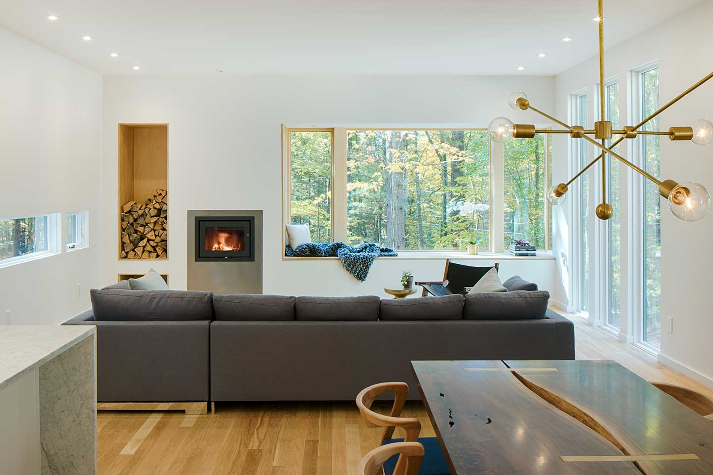 A contemporary living room featuring a window nook beneath a Marvin Ultimate Corner window.