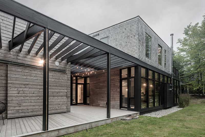 An exterior photo of the Unbridled Path residence, a contemporary home entirely clad in cedar shingles, featuring Marvin Elevate windows and doors.
