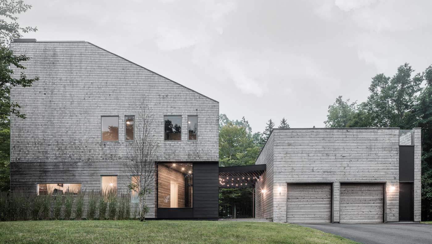An exterior photo of the Unbridled Path residence, a contemporary home entirely clad in cedar shingles, featuring Marvin Elevate windows and doors.