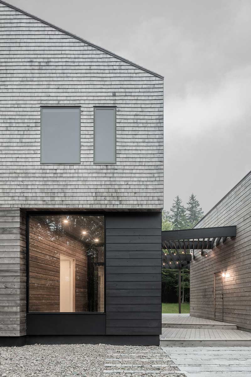 An exterior photo of the Unbridled Path residence, a contemporary home entirely clad in cedar shingles, featuring Marvin Elevate windows and doors.
