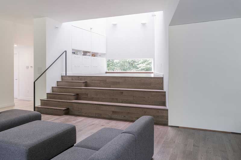 A wooden stage and play area inside a contemporary home for musicians, featuring Marvin Elevate windows and doors.