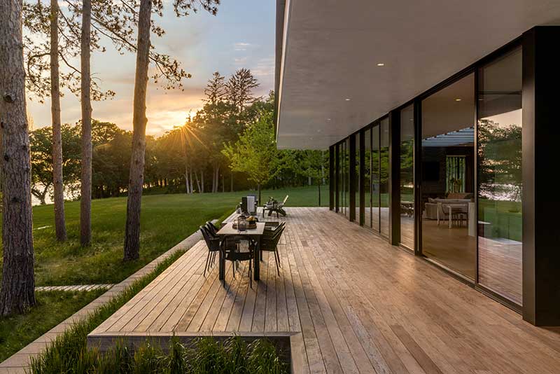 The patio of a modern home on Lake Minnetonka with Marvin Modern Multi Slide Doors and Marvin Modern Direct Glaze windows.