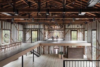 The second-floor mezzanine of The Church in Sag Harbor, New York, a former Methodist church converted into a center for the arts, featuring custom Marvin Ultimate windows with divided lights.