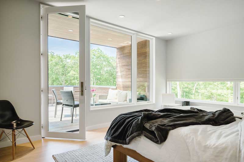 A white Marvin Ultimate Inswing French Door G2 leading from a bedroom to a porch.