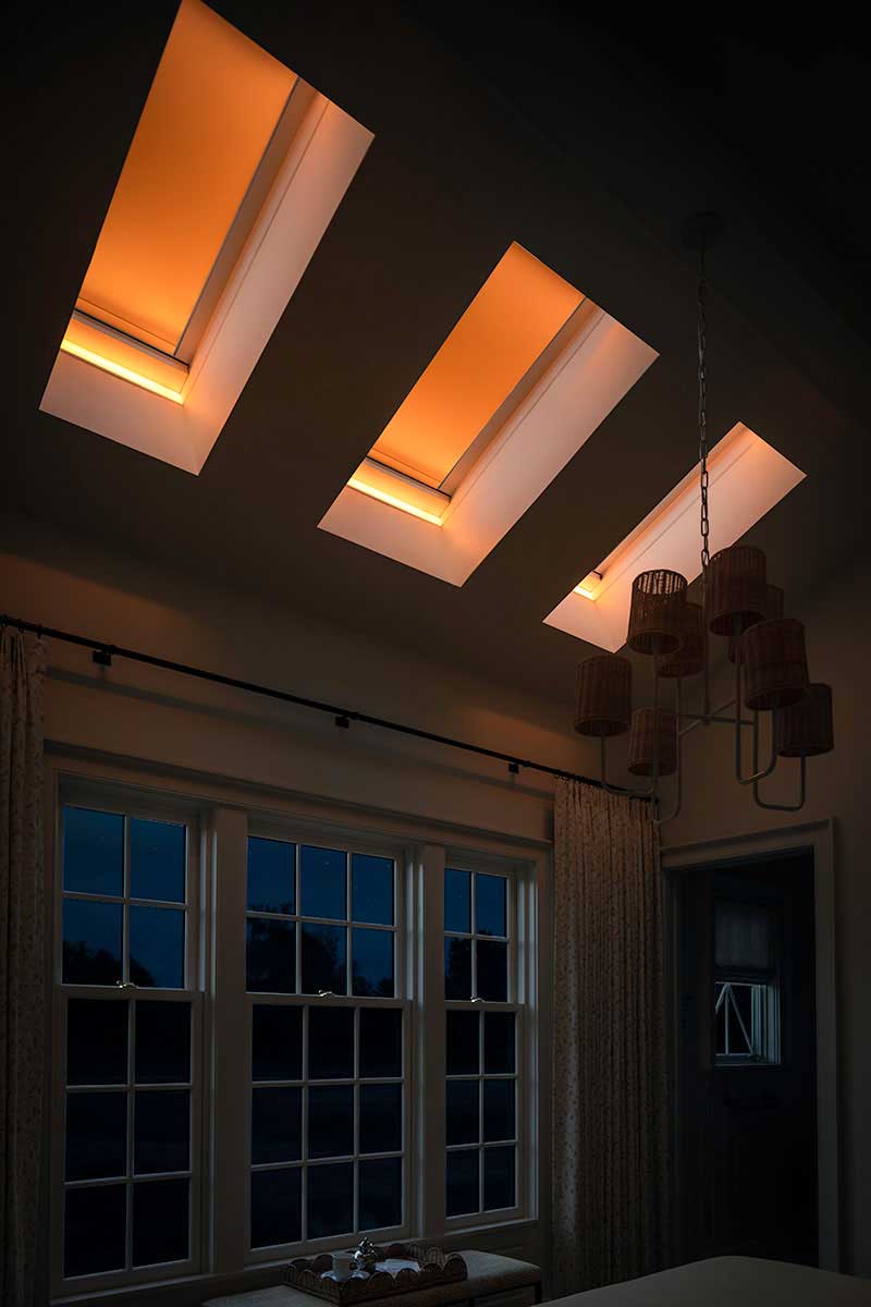 A dark bedroom at night in the Southern Living Idea House, featuring three Marvin Awaken Skylights and Ultimate Double Hung G2 windows.
