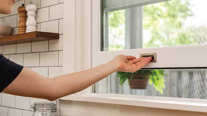 Homeowner operating a double hung window.