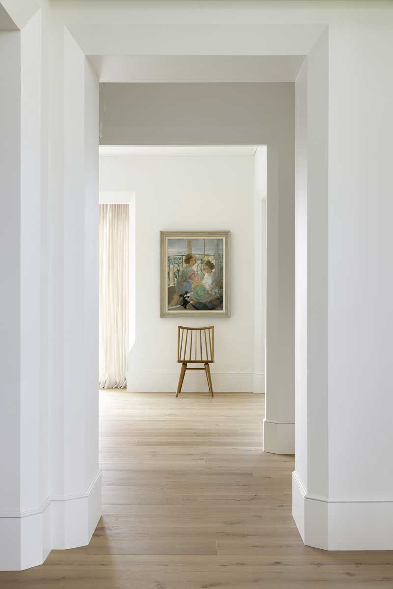 A long hallway with a chair at the end