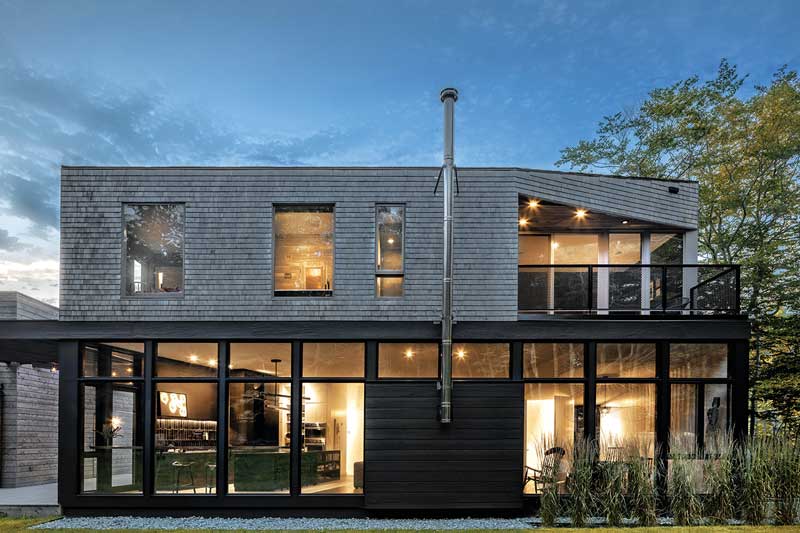 An exterior photo of the Unbridled Path residence, a contemporary home entirely clad in cedar shingles, featuring Marvin Elevate windows and doors.