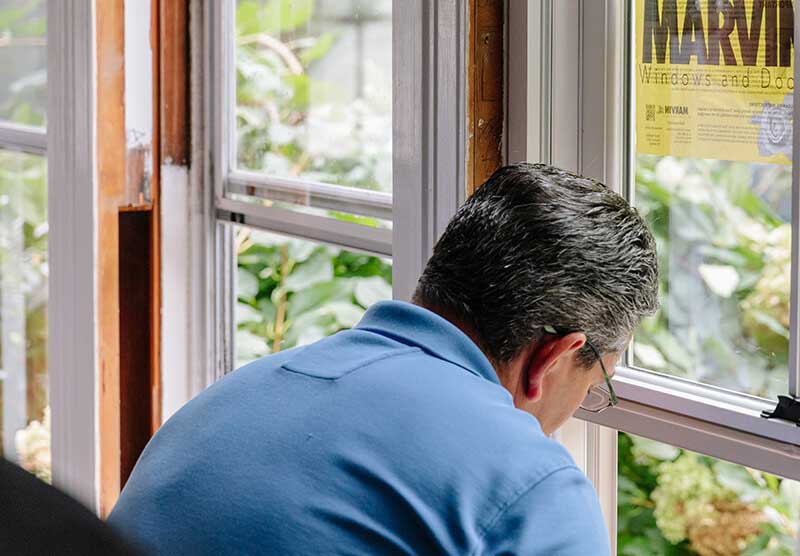 Window installer in the process of installing replacement windows.